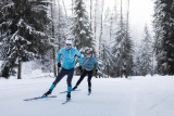 Deux skieurs sur une piste de ski nordique à travers les sapins au Grand-Bornand